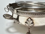 a silver plate with a bowl on top of it