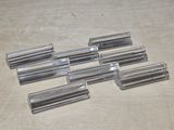 six clear glass tubes are lined up on a wooden surface