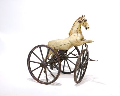 un cheval en jouet assis sur une petite calèche