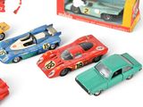 five toy cars in a box on a white surface