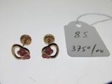une paire de boucles d'oreilles dorées ornées de pierres roses et d'une étiquette de prix