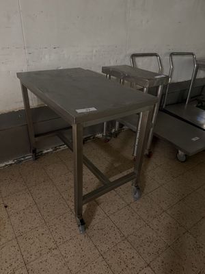 une table en métal avec deux chaises au milieu d'une pièce
