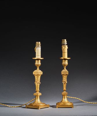 pair of antique brass candlesticks with candles on each of them