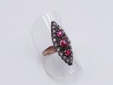 a close up of a ring with a red stone in it