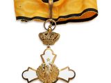 une image représentant une croix en or surmontée d'une couronne
