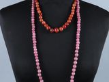 un collier de perles roses et rouges sur un buste de mannequin