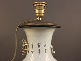 a white vase with a gold handle on a table