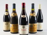 six bottles of wine are lined up in a row on a white surface