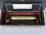 an old fashioned musical box with a gold and black music box inside