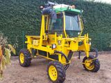 a yellow tractor that is parked in the dirt