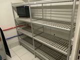 a person standing in a room with shelves and a microwave