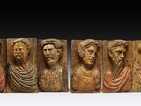 un ensemble de cinq plaques en bois sculptées représentant des hommes barbus