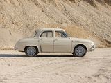a car that is parked in the sand near a hill