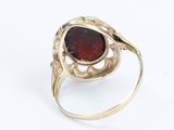 a close up of a gold ring with a red stone in it