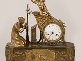 une horloge en or sur laquelle sont représentés un homme et une femme