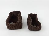 pair of brown crocheted baskets on a white surface