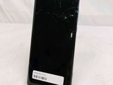 a close up of a cell phone with a broken screen on a table
