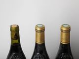 three bottles of wine sitting on top of a table next to each other