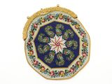 une image représentant un sac à main bleu et or orné d'un motif floral