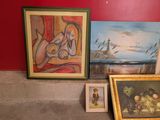 three paintings on the floor next to a red wall