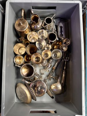une boîte remplie d'argent et d'argenterie posée sur une table