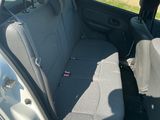 sur la banquette arrière d'une voiture argentée, avec un sac dans le coffre