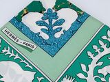 a green and white napkin with a picture of elephants on it