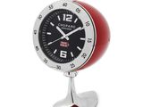 une image représentant une horloge rouge et noire posée sur un socle