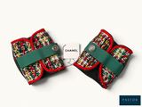 two small bows with red, green, and white designs are on a white surface