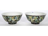 a pair of black and green bowls with flowers on them