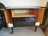 a small cabinet with a drawer on wheels in a room