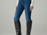 the woman is wearing a white shirt and black boots