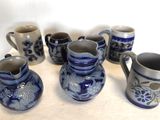 Plusieurs vases bleus et blancs sont alignés sur une table