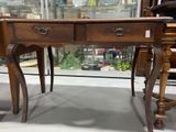 a wooden table with two drawers and a glass top