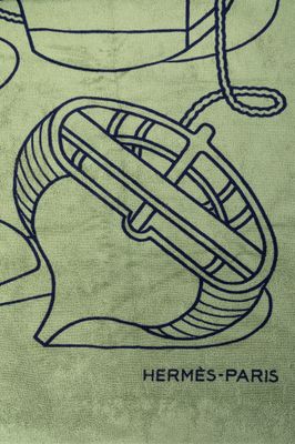 une serviette verte sur laquelle sont dessinés un bateau et un casque