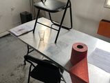 two chairs and a table with a roll of toilet paper on it