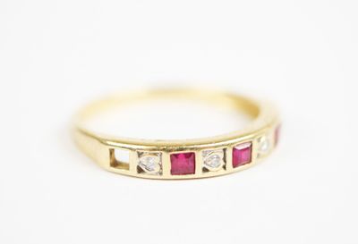 a close up of a yellow gold ring with ruby and diamonds