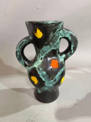 un vase noir et vert parsemé de taches orange