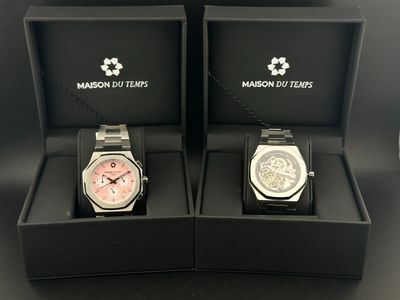 deux montres dans un coffret noir posé sur une surface noire
