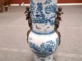 un vase bleu et blanc posé par terre