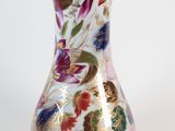 a vase with a floral design on it sitting on a table