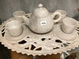 une table sur laquelle se trouvent une théière et des tasses