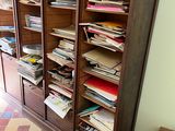 a wooden cabinet with many files on it in a room
