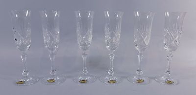 six verres à vin sont alignés sur une surface blanche