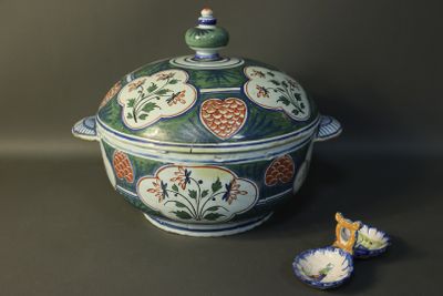 a bowl with a lid sitting on a table next to a bowl with a spoon in it
