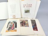 un livre ouvert posé sur une table à côté d'une pile de livres