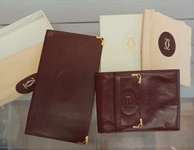 Trois portefeuilles en cuir sont posés les uns à côté des autres sur une table en verre.