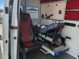 a red seat in the back of a white ambulance