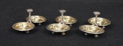 six silver plated candlesticks with candles on them on a black surface