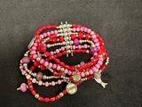 a close up of a bracelet with beads and charms on a black surface